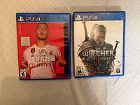 FIFA 20 and The Witcher 3 PS4 game cases front covers