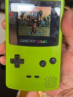 Front view of lime green Game Boy Color showing powered screen with game running