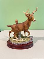 Full view of porcelain stag on wood base