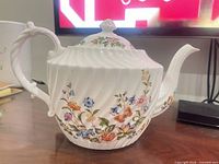 Left side view of teapot showing floral decoration and shape