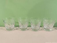 Four cut crystal old fashioned glasses in a row
