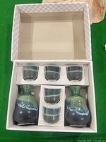 Boxed set showing 2 carafes and 5 cups in fitted packaging