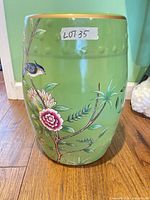 front view of green ceramic garden stool with bird and floral design