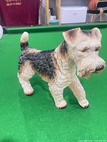 Front/left view of porcelain terrier figurine on green surface