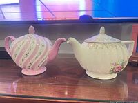 Both teapots side by side showing overall shapes, colours and lids