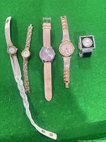 Five watches laid out showing different bands and cases