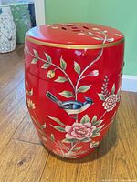 Full view of stool showing red glaze, bird and floral painting