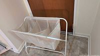 Folding laundry sorter open with three mesh compartments
