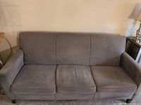 Front view of grey Flexsteel sofa showing three seat cushions and overall condition