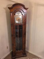 Full view of oak grandfather clock showing case and glass door