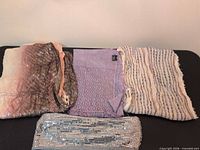 Four folded metallic scarves showing colors and textures