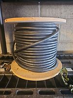 large wooden spool with black rubber cable