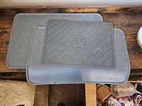 Three gray silicone mats stacked on wooden surface