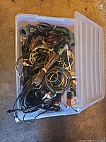 plastic tote filled with assorted cords and light socket sets