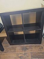 front view of black 4-cube bookshelf showing compartments