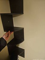 Full view of shelf showing zigzag five-tier design and black finish
