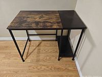 Full view of desk showing split-finish top and metal frame