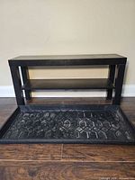 Front view of black shoe bench with boot tray