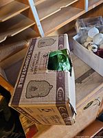 Cardboard box with open flap showing green liners