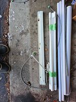 Overall view of fixture with cord and two bundles of LED tubes on floor