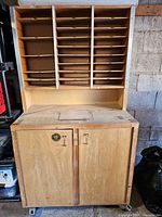 Front view of cabinet showing pigeonholes and closed lower doors