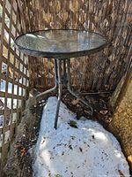 Full view of glass-top bistro table placed outdoors
