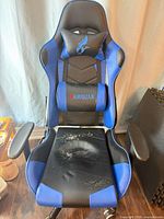 Front view of Hawguar gaming chair showing blue/black PU upholstery, lumbar and head pillows, seat peeling