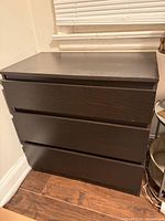 Front view of dark brown 3-drawer dresser showing overall design and finish