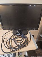 Front view of LG monitor on stand with cables