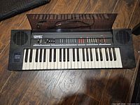 Front view of Lowrey Micro Genie keyboard showing full keybed, speaker grilles and control panel