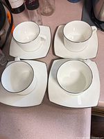 Four Mikasa teacups on matching square saucers