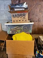 Overall view of MOSS LED shipping box atop tote with wires and additional boxes