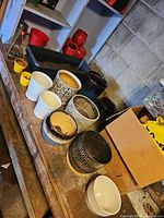 Overview of workbench with assorted ceramic planters of various colours and patterns