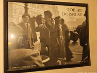 Robert Doisneau framed poster showing Paris street kiss, black frame visible
