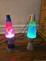 Both lava lamps illuminated and plugged in