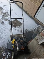 Full view of mower from front left angle showing handle, deck, wheels