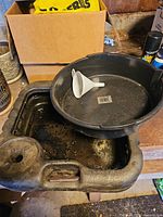 Square and round oil drain pans with funnel shown together