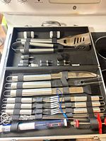 Open case showing all stainless steel BBQ tools neatly strapped in
