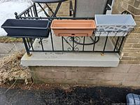 Three planter boxes mounted on railing showing colors and brackets