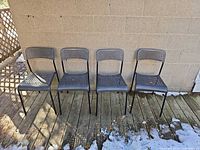 front view of all four black perforated chairs side by side