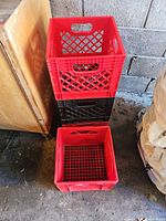 Stack of red and black plastic milk crates
