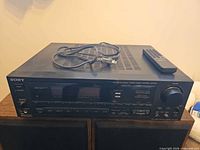 Front angled view of Sony receiver with power cord and remote placed on top