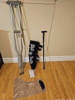 Lot overview showing crutches, knee brace, cane, protector