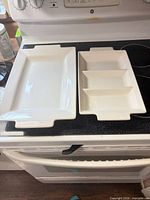 Both ceramic serving pieces side by side on stove for scale