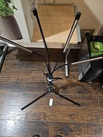 Full view of LED grow light on tripod with four gooseneck bars and remote on floor