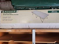 Boxed Woods camp cot showing product image and branding