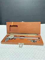 Caliper in open wooden box, full view
