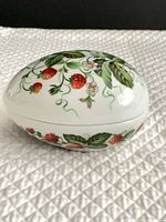 Closed porcelain egg trinket box showing strawberry pattern