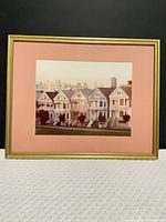 Full view of framed print with pink mat and gold frame