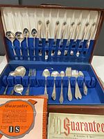 Open chest showing full flatware set arranged in blue-lined slots